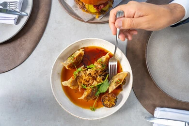 Enjoying delicious food, stuffed chicken dish immersed in a rich sauce of flavors, garnished with basil leaves, grilled lemon, and fresh spices, Arab Gulf Emirati restaurants, tasty and delicious recipes and dishes, presentation arts in the kitchens of the United Arab Emirates.