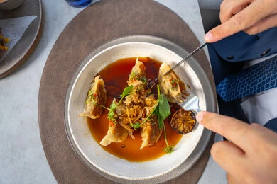 وصفات وأطباق شهية ولذيذة، طبق الدجاج المحشو مغمور بصلصة غنية بالنكهات مزين بأوراق الريحان والليمون المشوي وتوابل طازجة، وجبات الطعام الشهية، مطاعم عربية خلجية اماراتية، فنون التقديم في مطابخ الامارات العربية المتحدة