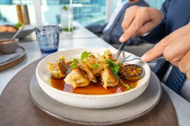 طبق الدجاج المحشو مغمور بصلصة غنية بالنكهات مزين بأوراق الريحان والليمون المشوي وتوابل طازجة، وجبات الطعام الشهية، مطاعم عربية خلجية اماراتية، وصفات وأطباق شهية ولذيذة، فنون التقديم في مطابخ الامارات العربية المتحدة