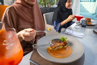 The art of presentation in restaurants and kitchens of the United Arab Emirates, the art of etiquette and dining manners, seafood and healthy dishes, grilled salmon fillet with sauce and green vegetables, delicious meals, Arab Gulf Emirati restaurants, tasty and delicious recipes and dishes.