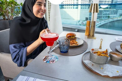 طاوله مليئه بأصناف المأكولات والمشروبات، اجتماع عمل في مكان خارج مقر الشركة, مشاركة الأوقات الممتعة, مجموعة من الأصدقاء العربيين الخليجيين الإماراتيين يجلسون على مائدة في إحدى المطاعم في الإمارات، قضاء أوقات ممتعة مع الأصدقاء