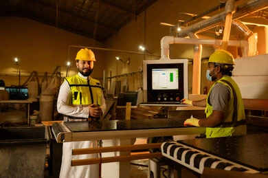 الاشراف على سير خطة العمل، مصانع ومعامل في المملكة العربية السعودية، النظر إلى الكاميرا بتعابير السرور, مهندس عربي خليجي سعودي يرتدي الثوب و الخوذة وسترة الحماية يقف داخل المصنع، معمل صناعة الخشب