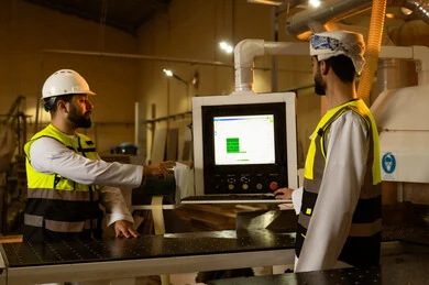 Monitoring the performance of laboratory devices, popular crafts and manual professions, the concept of discussions and dialogues, a wooden furniture manufacturing workshop, two Arab Gulf engineers from Saudi Arabia wearing safety vests and helmets supervising the progress of the work plan.