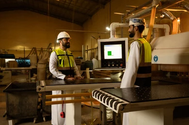 حرف ومهن يدوية شعبية، مفهوم الناقشات والحوارات، متابعة أداء آلات المختبر اليومية، معمل تصنيع الأثاث الخشبي، مهندسان عربيان خليجيان سعوديان يرتديان سترة وخوذة الحماية يشرفان على سير خطة العمل