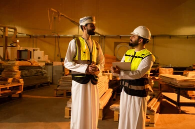 الإشراف على تشغيل المعدات المعملية، تسجيل وتوثيق الملاحظات، معمل تصنيع الأثاث الخشبي، مفهوم الناقشات والحوارات، مهندسان عربيان خليجيان سعوديان يرتديان سترة وخوذة الحماية يشرفان على سير خطة العمل، حرف ومهن يدوية شعبية