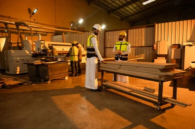 توثيق الأفكار والملاحظات، معمل تصنيع الأثاث الخشبي، مفهوم الناقشات والحوارات، مهندسان عربيان خليجيان سعوديان يرتديان سترة وخوذة الحماية يشرفان على سير خطة العمل، حرف ومهن يدوية شعبية، ورشات النجارة في المملكة العربية السعودية