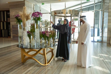 زوجان عربيان خليجيان اماراتيان يرتديان الزي التقليدي يقفان في بهو الفندق السياحي ، قضاء أجمل الأوقات في أفضل الفنادق الخليجية ، رحلة زوجية ممتعة ، عطلة نهاية الأسبوع ، مفهوم الأسرة السعيدة، الاشارة الى شيء ما