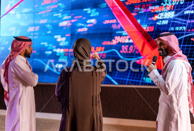 مذيع عربي خليجي سعودي في مقابلة مع سيدة ورجل اعمال خليجيين سعوديين، شرح سوق الاوراق المالية  ، تحليل البيانات المالية ، متابعة صعود ونزول الاسهم ، شراء وبيع الاسهم في البورصة ، الاستثمار المالي والاقتصادي ، الأخبار التجارية والمالية