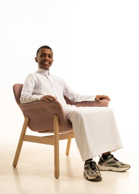 Enjoying the calm atmosphere, the concept of comfort and relaxation, the feeling of fatigue and lethargy, a portrait of a smiling Arab Gulf Saudi man wearing traditional attire sitting on a comfortable chair with expressions of relaxation, white background.