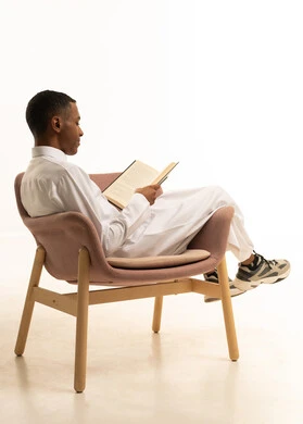 مراجعة الدروس للمذاكرة والاختبارات المدرسية، إيماءات الاجتهاد والتفوق، تطوير المناهج التعليمية في السعودية, بورتريه من الجانب لشاب مراهق عربي خليجي سعودى مبتسم يرتدي الثوب التقليدى مستلقي على الكرسي يمسك بيده الكتاب المدرسي، خلفية بيضاء