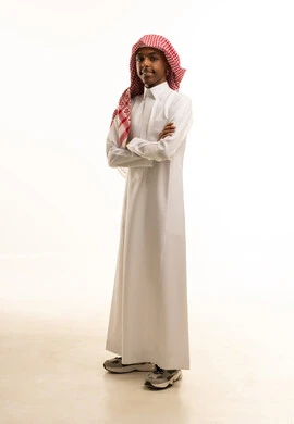 Standing with arms crossed and expressions of self-confidence, a side portrait of a smiling Saudi Arabian Gulf boy wearing traditional attire and a shemagh, looking at the camera with gestures of joy, ready for the start of the new school year, full-body image, white background. Standing with arms crossed and expressions of self-confidence, a side portrait of a smiling Saudi Arabian Gulf boy wearing traditional attire and a shemagh, looking at the camera with gestures of joy, ready for the start of the new school year, full-body image, white background.