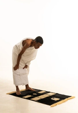 Drawing closer to God and striving in worship, performing prayers on time, the rituals of Hajj and Umrah, a side portrait of a young Saudi Arabian Gulf man wearing Ihram clothing, bowing on a prayer rug with gestures of humility, supplication, and pleading, against a white background. Drawing closer to God and striving in worship, performing prayers on time, the rituals of Hajj and Umrah, a side portrait of a young Saudi Arabian Gulf man wearing Ihram clothing, bowing on a prayer rug with gestures of humility, supplication, and pleading, against a white background.