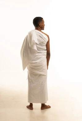 مفهوم أركان الإسلام، بورتريه من الخلف لرجل مسلم خليجي عربي سعودي يرتدي ملابس الإحرام، أداء مناسك الحج و العمرة، خلفية بيضاء