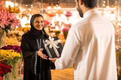 مفهوم الود والالفه، زوجان عربيان خليجيان سعوديان سعيدان يحتفلان بعيد الحب , الزوج يقدم لزوجته علبة هدايا , الزوجة تعبر بإيماءات وجه ويدين تدل على الدهشة والفرح , يوم عيد الفلانتاين , أعياد ومناسبات سعيده , الاحتفال بعيد الميلاد , خلفية محل بيع الورود. مفهوم الود والالفه، زوجان عربيان خليجيان سعوديان سعيدان يحتفلان بعيد الحب , الزوج يقدم لزوجته علبة هدايا , الزوجة تعبر بإيماءات وجه ويدين تدل على الدهشة والفرح , يوم عيد الفلانتاين , أعياد ومناسبات سعيده , الاحتفال بعيد الميلاد , خلفية محل بيع الورود.