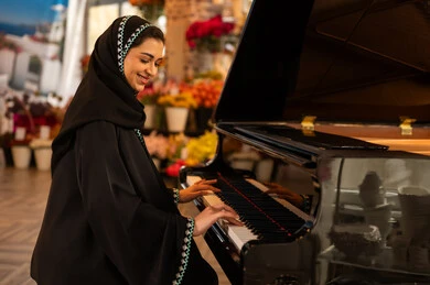 قضاء الوقت بالعزف على الألات الوترية، الطرب والانشطة ترفيهية،امراة عربية خليجيه سعوديه فنانه ترتدي العباءه والحجاب تجلس امام آلة البيانو الموسيقية وتستمتع بالعزف ، مواهب فنية موسيقية،  تقديم البرامج والفنون الموسيقية والفن المسرحي