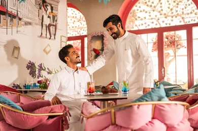 لمة الاصدقاء فى عطلة نهاية الاسبوع , مشاركة المشروبات الباردة, تجمع لاصدقاء عرب خليجيين سعوديين يقومون بتبادل الاحاديث والاخبار، تعابير السرور والبهجة ، ايماءات السعادة بقضاء اوقات ممتعه مع الاصحاب