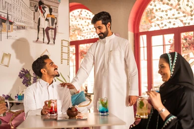 Expressions of joy and happiness, sharing cold drinks, a group of Arab Gulf Saudi friends exchanging conversations and news, gestures of happiness spending enjoyable times with friends, gathering of friends on the weekend.