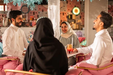 لمة الاصدقاء فى عطلة نهاية الاسبوع، مشاركة المشروبات الباردة, مجموعة اصدقاء عرب خليجيين سعوديين يقومون بتبادل الاحاديث والاخبار، تعابير السرور والبهجة ، ايماءات السعادة بقضاء اوقات ممتعه مع الاصحاب