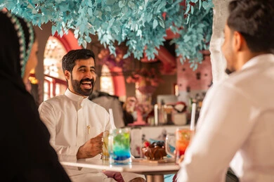 تعابير السرور والبهجة ، مشاركة المشروبات الباردة, مجموعة اصدقاء عرب خليجيين سعوديين يقومون بتبادل الاحاديث والاخبار، ايماءات السعادة بقضاء اوقات ممتعه مع الاصحاب, لمة الاصدقاء فى عطلة نهاية الاسبوع