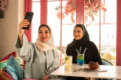 Watching movies and series on mobile, spending enjoyable times with friends, discussing and conversing in calm atmospheres, sharing cold drinks, two Arab Gulf friends from Saudi Arabia wearing abayas and hijabs sitting in one of the upscale cafes using a mobile phone, using modern technology. Watching movies and series on mobile, spending enjoyable times with friends, discussing and conversing in calm atmospheres, sharing cold drinks, two Arab Gulf friends from Saudi Arabia wearing abayas and hijabs sitting in one of the upscale cafes using a mobile phone, using modern technology.