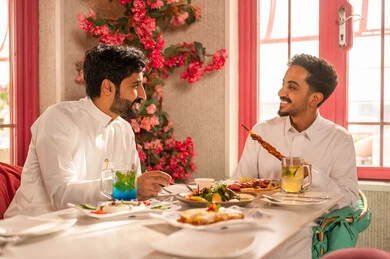 ايماءات السعادة بقضاء اوقات ممتعه مع الاصحاب, تبادل الأحاديث والاخبار, عزومة غداء لصديقان عربيان خليجيان سعوديان يقومان بتناول الأطعمة في أحد المطاعم الفاخرة، تعابير السرور والبهجة ،مائدة طعام مليئة بأصناف من المأكولات والمقبلات الشهية,لمة الاصدقاء على سفرة الإفطار الشهية