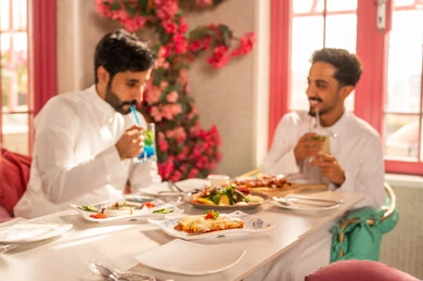 مائدة طعام مليئة بأصناف من المأكولات والمقبلات الشهية, تبادل الأحاديث والاخبار, عزومة غداء لصديقان عربيان خليجيان سعوديان يقومان بتناول الأطعمة في أحد المطاعم الفاخرة، تعابير السرور والبهجة ،ايماءات السعادة بقضاء اوقات ممتعه مع الاصحاب, لمة الاصدقاء على سفرة الإفطار الشهية