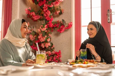 A variety of different dishes and delicious appetizers, gestures of happiness spending enjoyable times with friends, a gathering of friends at a delicious breakfast table, expressions of joy and delight, a close-up image of a lunch invitation for Saudi Gulf Arab friends enjoying food at one of the luxurious restaurants.