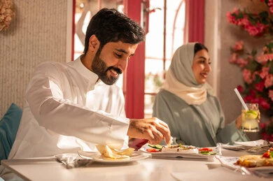 ايماءات السعادة بقضاء اوقات ممتعه مع الاصحاب, تعابير السرور والبهجة ،مائدة طعام مليئة بأصناف من المأكولات والمقبلات الشهية,لمة الاصدقاء على سفرة الإفطار الشهية, صورة مقربة لعزومة غداء لاصدقاء عرب خليجيين سعوديين  يقومون بتناول الأطعمة في أحد المطاعم الفاخرة