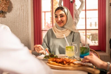 اجتماع فى عطلة نهاية الاسبوع ، مائدة طعام مليئة بأصناف من المأكولات والمقبلات الشهية, ايماءات السعادة بقضاء اوقات ممتعه مع الاصحاب, لمة الاصدقاء على سفرة الإفطار الشهية, صورة مقربة لعزومة غداء لاصدقاء عرب خليجيين سعوديين  يقومون بتناول الأطعمة في أحد المطاعم الفاخرة