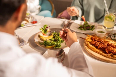 اطباق متنوعه ومختلفة من المأكولات والمقبلات الشهية, ايماءات السعادة بقضاء اوقات ممتعه مع الاصحاب, لمة الاصدقاء على سفرة الإفطار الشهية, صورة مقربة لعزومة غداء لاصدقاء عرب خليجيين سعوديين  يقومون بتناول الأطعمة في أحد المطاعم الفاخرة