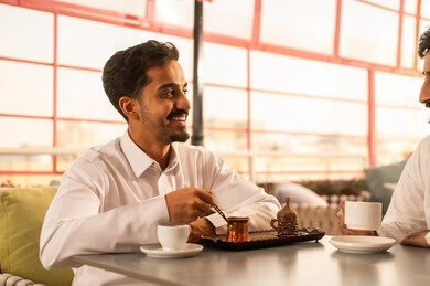 مشاركة المشروبات الساخنة مع الاصدقاء ، كوفي شوب راقي بالمملكة العربية السعودية، تعابير السعادة والسرور بلمة الرفاق، تطوير العلاقات الإجتماعية، قضاء وقت ممتع مع الأصدقاء، الاستمتاع بالاجواء السعيده ، صديقان عربيان خليجيان سعوديان يرتديان الثوب الابيض يجلسان على طاولة في المقهى مشاركة المشروبات الساخنة مع الاصدقاء ، كوفي شوب راقي بالمملكة العربية السعودية، تعابير السعادة والسرور بلمة الرفاق، تطوير العلاقات الإجتماعية، قضاء وقت ممتع مع الأصدقاء، الاستمتاع بالاجواء السعيده ، صديقان عربيان خليجيان سعوديان يرتديان الثوب الابيض يجلسان على طاولة في المقهى