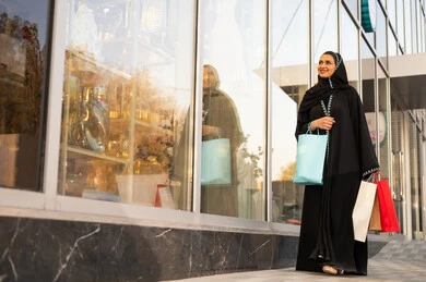 امراه عربيه خليجيه سعوديه ترتدي العباءه والحجاب تنظر الى شيء ما في وقت النهار، الفخر والاعتزاز بالتقدم المعماري ، النمو والتطور العمراني في السعودية ، ايماءات السرور والسعادة ، التجول واستنشاق الهواء النقي في الخارج