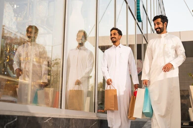 الفخر والاعتزاز بالتقدم المعماري ، التجول واستنشاق الهواء النقي في الخارج, النمو والتطور العمراني في السعودية ، رجلان عربيان خليجيان سعوديان يرتديان الثوب الابيض ينظران الى شيء ما في وقت النهار