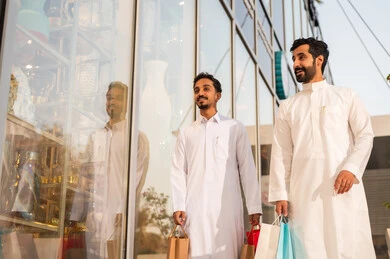 التجول واستنشاق الهواء النقي في الخارج, الفخر والاعتزاز بالتقدم المعماري ، النمو والتطور العمراني في السعودية ، رجلان عربيان خليجيان سعوديان يرتديان الثوب الابيض ينظران الى شيء ما في وقت النهار