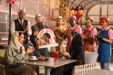 كيكة مزينة مع الشموع ، الاستمتاع بالمناسبات وأعياد الميلاد، امراه عربية خليجية سعودية ترتدي العباءه والحجاب تحتفل بعيد ميلاد صديقتها ، أجواء فرحة  واحتفالات ، المشاركة بأعياد ميلاد، مفهوم الاستمتاع  والترفيه ، تعابير الود والالفة