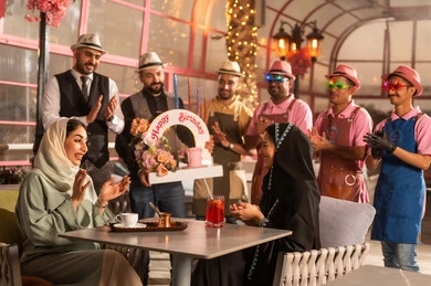 الاستمتاع بالمناسبات وأعياد الميلاد، امراه عربية خليجية سعودية ترتدي العباءه والحجاب تحتفل بعيد ميلاد صديقتها ، أجواء فرحة  واحتفالات ، المشاركة بأعياد ميلاد، كيكة مزينة مع الشموع ، مفهوم الاستمتاع  والترفيه ، تعابير الود والالفة