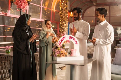 كيكة مزينة مع الشموع ، الاحتفال بأعياد الميلاد، عائلة عربية خليجية سعودية تحتفل بعيد ميلاد صديقتهم فى المقهى ، أجواء فرحة  واحتفالات ، المشاركة بأعياد ميلاد، مفهوم الاستمتاع  والترفيه ، تعابير الود والالفة