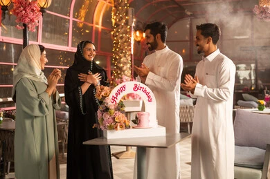 تعابير الود والالفة،  الاحتفال بأعياد الميلاد، عائلة عربية خليجية سعودية تحتفل بعيد ميلاد صديقتهم فى المقهى ، أجواء فرحة  واحتفالات ،كيكة مزينة مع الشموع ، مفهوم الاستمتاع  والترفيه