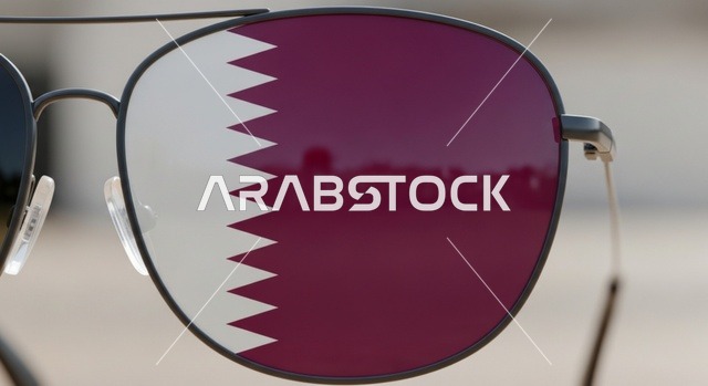 الأعياد والمناسبات الوطنية، إحياء ذكرى تأسيس الدولة، الاحتفال باليوم الوطني القطري 18 ديسمبر،صورة مقربة لنظارة شمسية يعكس فيها علم قطر يرمز للفخر والانتماء الوطني، رموز وثقافات وطنية، حب الوطن والانتماء إليه، مفهوم الحب والانتماء للبلاد