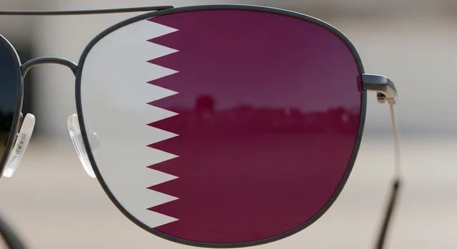 National holidays and occasions, commemorating the founding of the state, celebrating Qatar National Day on December 18, a close-up image of sunglasses reflecting the Qatari flag symbolizing pride and national belonging, national symbols and cultures, love for the homeland and belonging to it, the concept of love and belonging to the country.