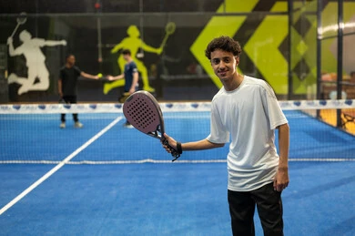 Physical and youth entertainment, playing tennis in public courts, a young Arab Gulf Saudi man wearing sportswear practicing lawn tennis, the concept of fitness and agility, the Saudi Tennis Federation.