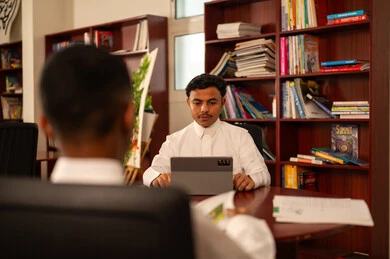 أهمية العلم في تنمية القدرات العقلية، مفهوم الاجتهاد وطلب التفوق، ايماءات الاندماج و التركيز، التربية والتعليم في الممكلة العربية السعودية، طالبان عربيان خليجيان سعوديان يرتديان الثوب الابيض يجلسان داخل المكتبة المدرسية ، استخدام التابلت فى الدراسة