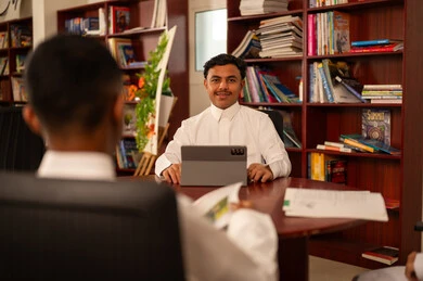 النظر الى الكاميرا بتعابير السعادة و السرور ، مفهوم الاجتهاد وطلب التفوق، أهمية العلم في تنمية القدرات العقلية، التربية والتعليم في الممكلة العربية السعودية، طالبان عربيان خليجيان سعوديان يرتديان الثوب الابيض  يجلسان داخل المكتبة المدرسية ، استخدام التابلت فى الدراسة