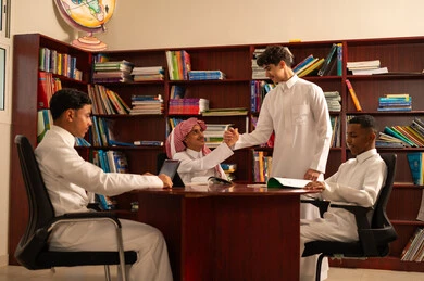 الترحيب و السلام و إلقاء التحية، دعم العلاقات الودية بين الطلبة، العمل الجماعي والتعاون بين الزملاء، مفهوم الاجتهاد وطلب التفوق، التربية والتعليم فيالمملكة العربية السعودية، مجموعه من الطلاب العربيون الخليجيون السعوديون يرتدون الثوب الابيض يجلسون داخل مكتبه المدرسة، استخدام جهاز التابلت فى الدراسة