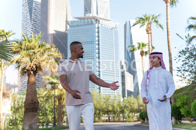 شابان عربيان خليجيان سعوديان يقومان بجولة داخل المدينة المالية ، الاستجمام و التنزه في الهواء الطلق ، لقاء و تعارف ، مقابلة أصدقاء ، قضاء وقت ممتع في مدينة الملك عبد الله المالية ( كافد ) في مدينة الرياض ، المملكة العربية السعودية