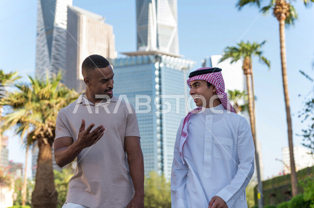 Two Saudi Arabian Gulf youths taking a tour inside the financial city, recreation and hiking in the fresh air, meeting and acquaintance, meeting friends, spending quality time in King Abdullah Financial City (KAFED) in the city of Riyadh, Kingdom of Saudi