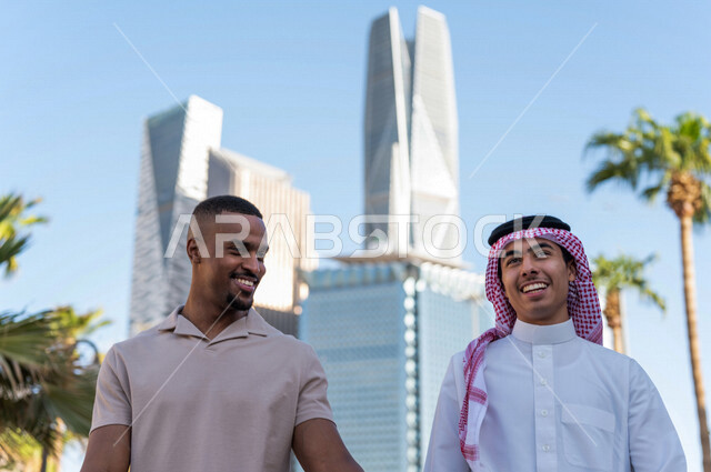 شابان عربيان خليجيان سعوديان يقومان بجولة داخل المدينة المالية ، الاستجمام و التنزه في الهواء الطلق ، لقاء و تعارف ، مقابلة أصدقاء ، قضاء وقت ممتع في مدينة الملك عبد الله المالية ( كافد ) في مدينة الرياض ، المملكة العربية السعودية