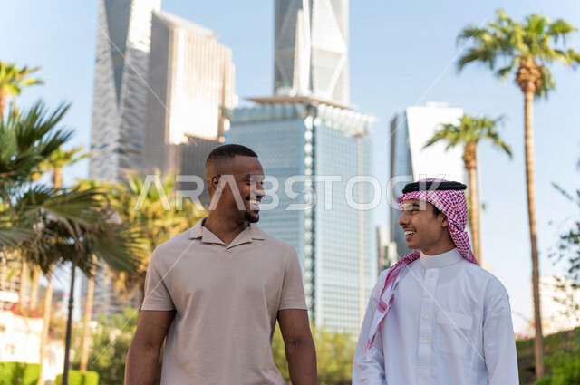 شابان عربيان خليجيان سعوديان يقومان بجولة داخل المدينة المالية ، الاستجمام و التنزه في الهواء الطلق ، لقاء و تعارف ، مقابلة أصدقاء ، قضاء وقت ممتع في مدينة الملك عبد الله المالية ( كافد ) في مدينة الرياض ، المملكة العربية السعودية