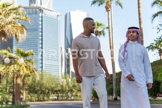 Two Saudi Arabian Gulf youths taking a tour inside the financial city, recreation and hiking in the fresh air, meeting and acquaintance, meeting friends, spending quality time in King Abdullah Financial City (KAFED) in the city of Riyadh, Kingdom of Saudi