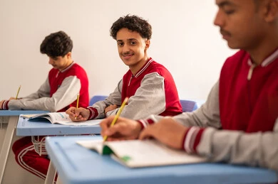 تعابير تدل على التفكير العميق والتركيز، التعليم في المملكة العربية السعودية، الاجتهاد في الدراسة لتحقيق النجاح والتميز الدراسي , اهداف التربية و التعليم، مجموعه من الطلاب العرب الخليجيون السعوديون يرتدون  الزي المدرسي يقومون بحل اسئله الامتحان